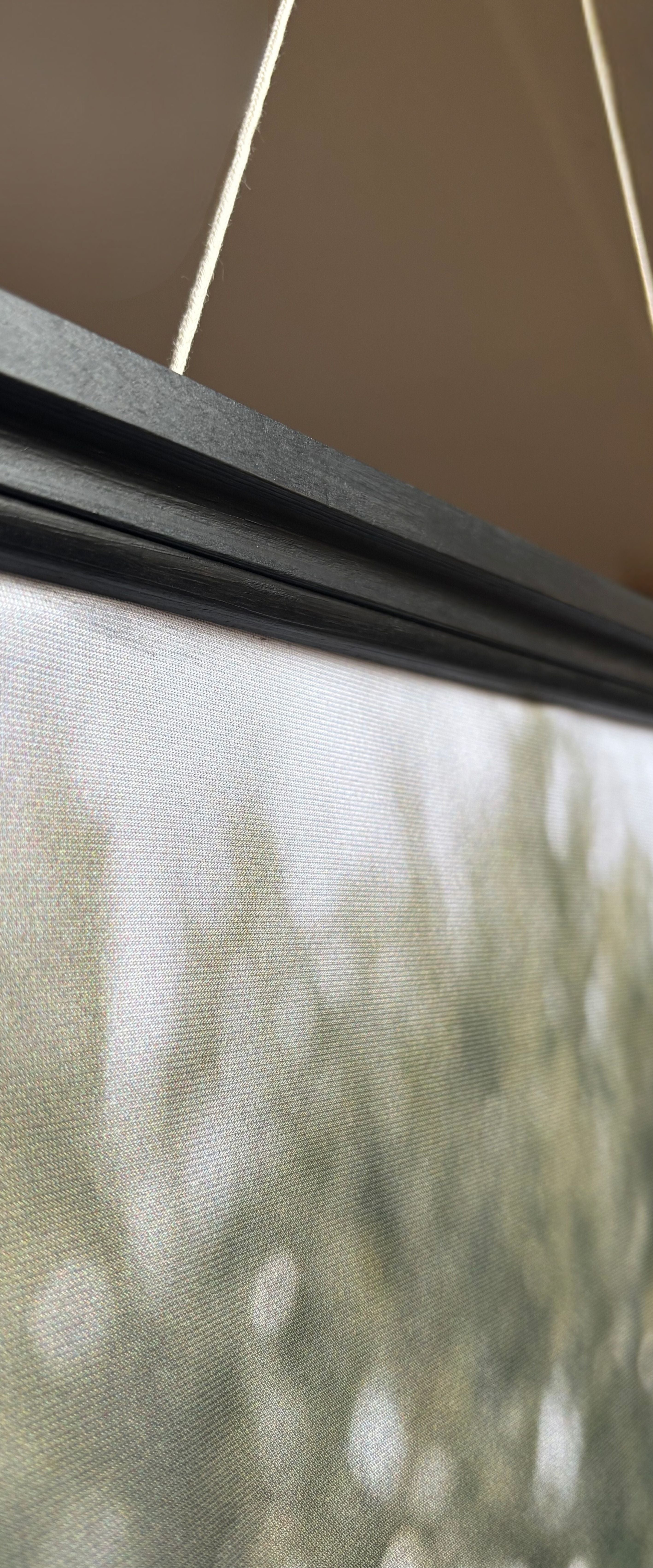 Vue détaillée du système de fixation supérieur avec barre en bois rigide noire pour bannière 75×180 cm