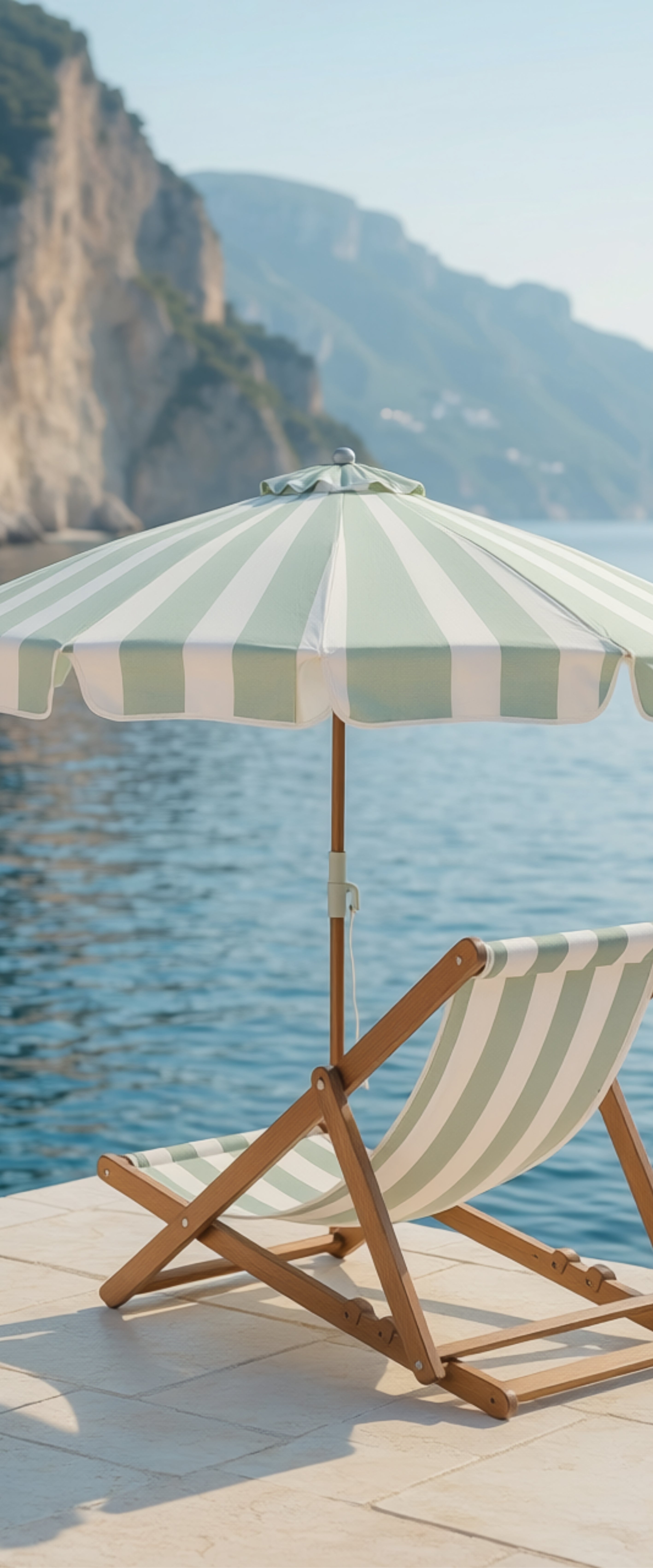 Banner décoratif Italian coast - Transat en bois rayé beige et blanc avec parasol vert sauge sur ponton face à la mer turquoise, ambiance Côte Amalfitaine