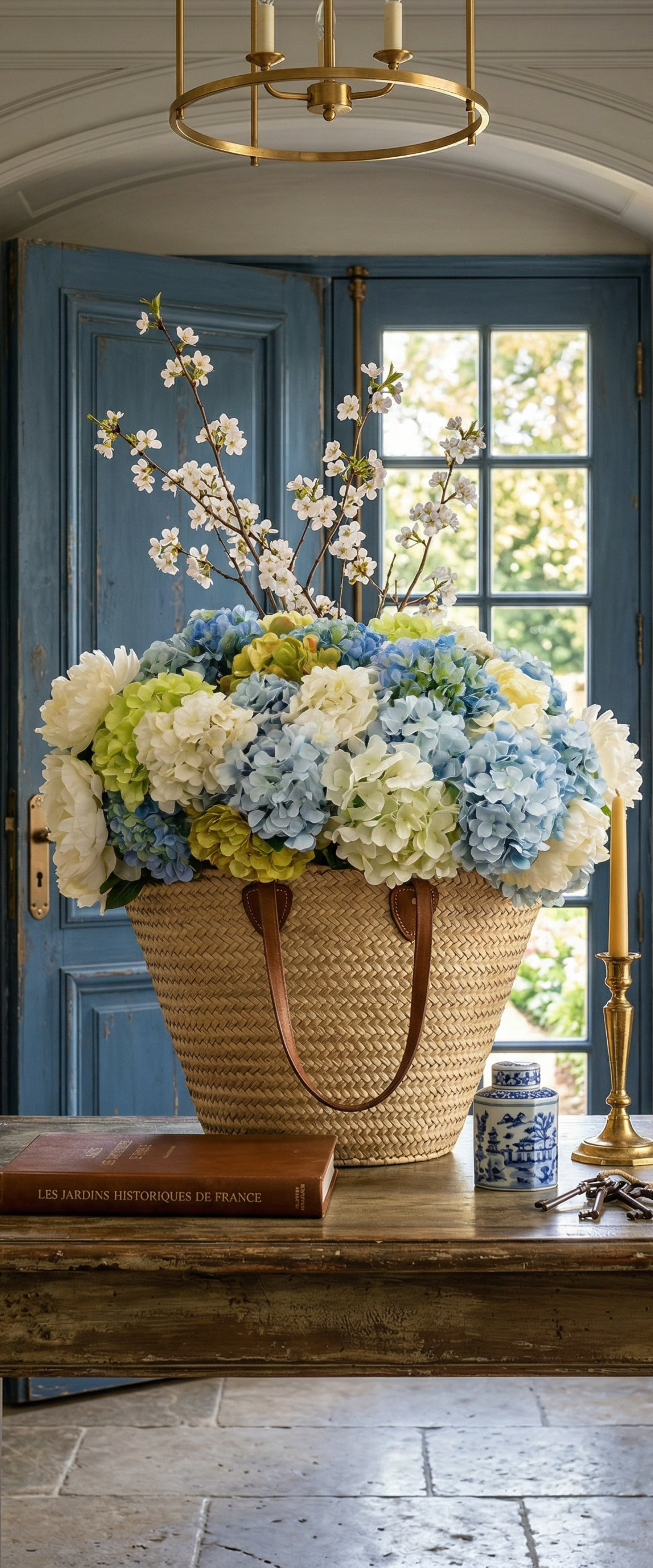 Banner décoratif Bouquet d'hortensias - Grand panier osier avec hortensias bleus blancs verts, branches fleuries, console bois, porte bleu canard, lustre laiton, ambiance élégante