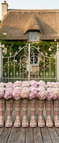 Banner décoratif Les bottes - Bottes en caoutchouc tartan rose remplies d'hortensias roses et blancs devant chaumière anglaise avec portail blanc