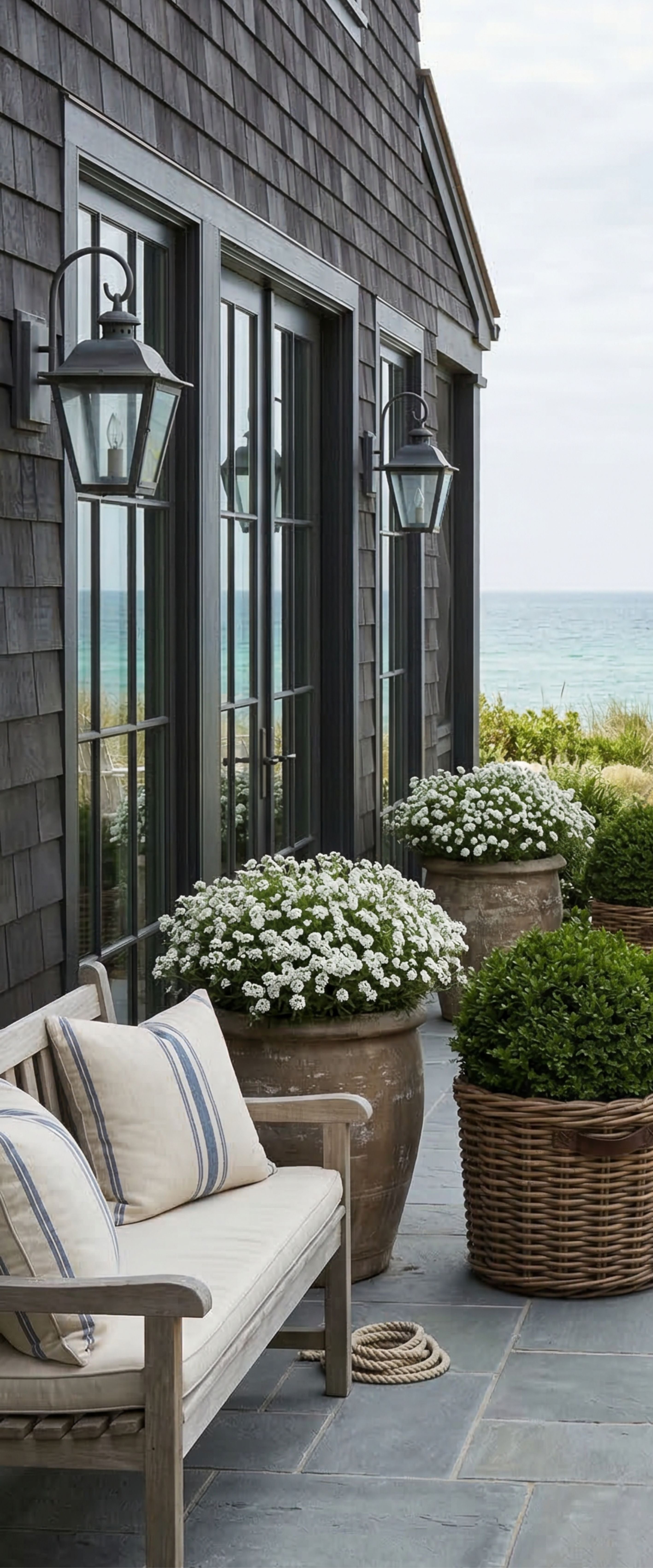 Banner décoratif Pavillon des dunes - Pavillon en bardeaux gris avec portes noires, marguerites blanches et vue sur mer, style Hamptons