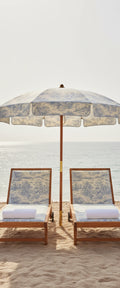 Banner décoratif Transat pour deux - Deux transats en bois avec parasol motif toile de Jouy bleu et blanc sur plage de sable fin face à la mer