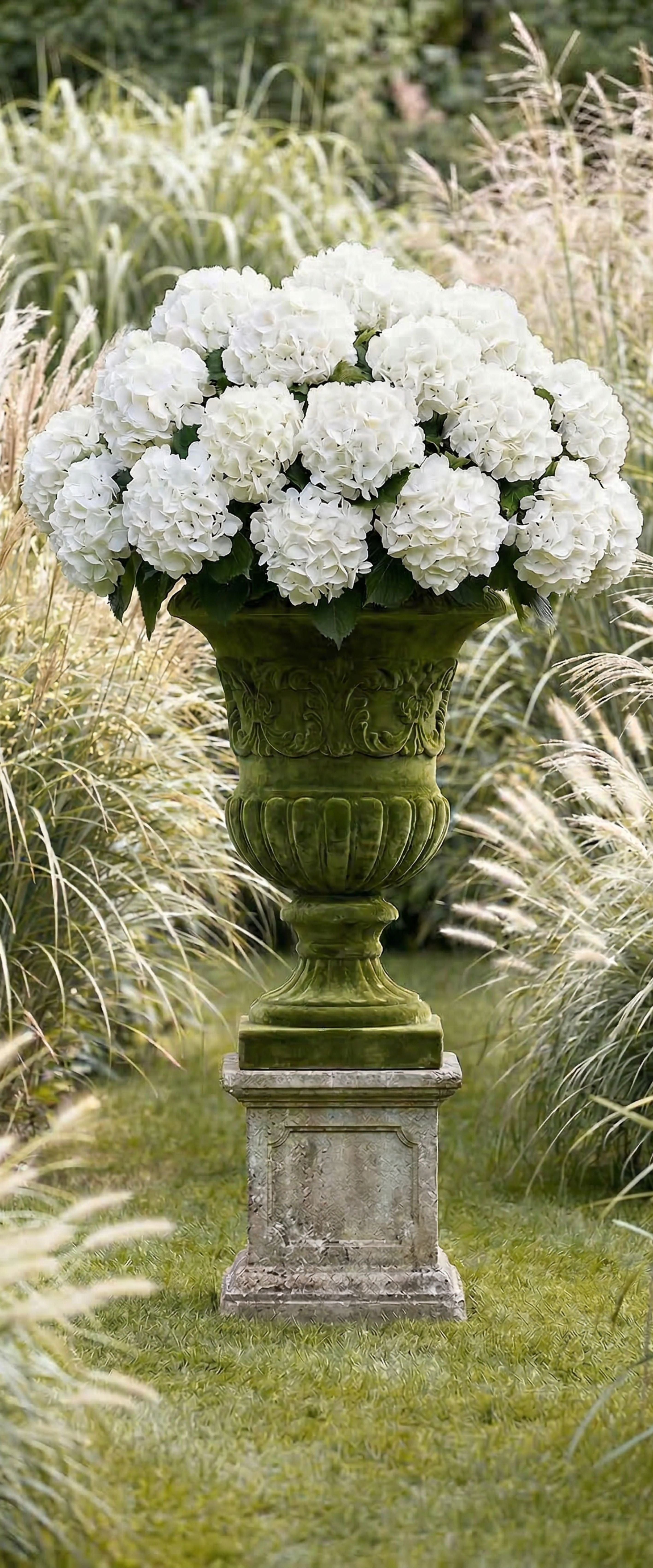 Banner décoratif Vasque Médicis - Urne Médicis vert mousse avec hortensias blancs sur piédestal en pierre, ambiance jardin à la française